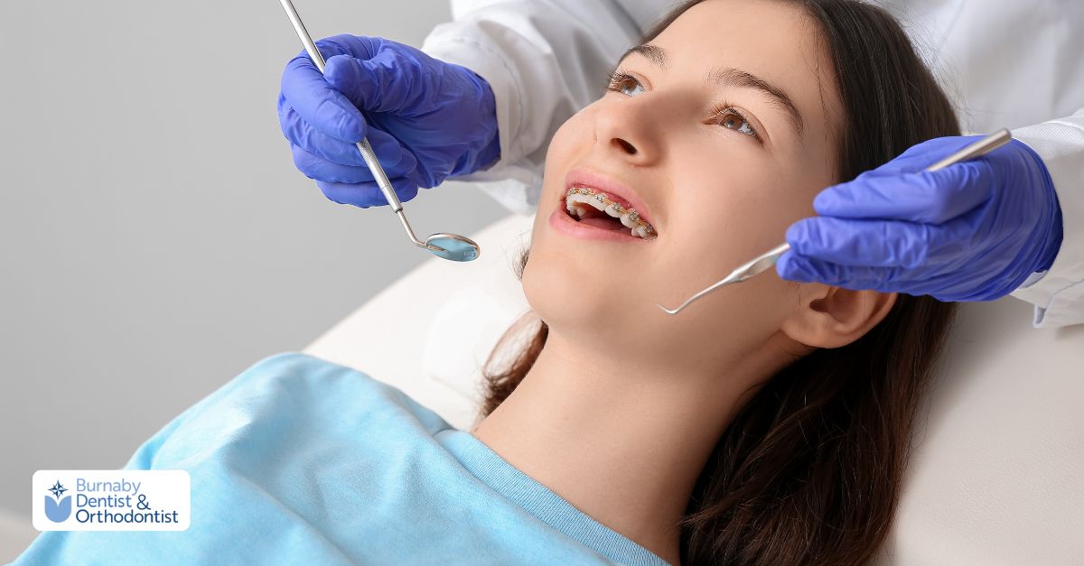 A dentist checks the teeth of a young girl in a dental office, focusing on her orthodontic treatment.