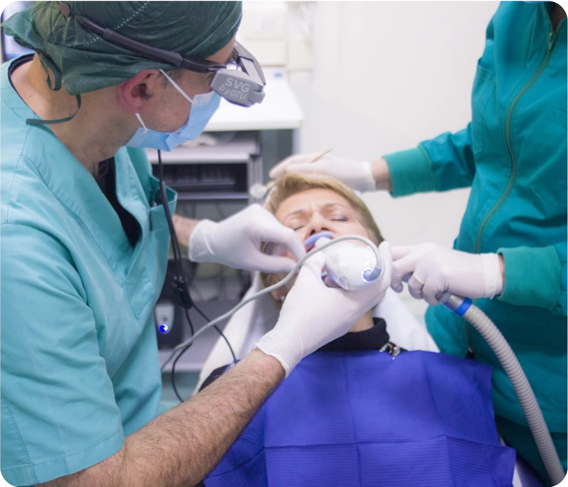 Dentist administering anesthesia with a mask to a patient before a dental procedure.