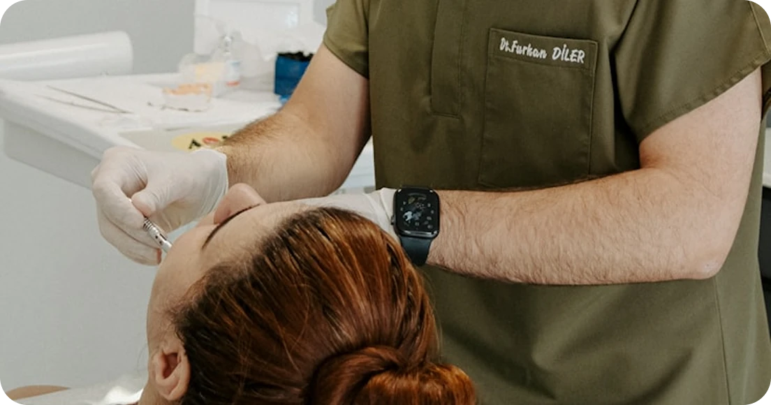 Dentist examining a patient’s mouth with hands while wearing gloves
