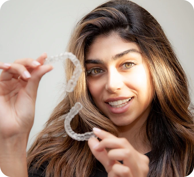 a woman holding invisalign braces