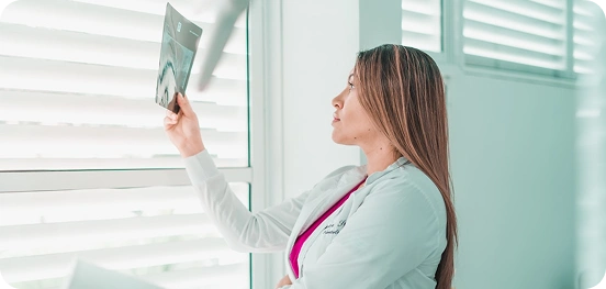 Female dentist examining a dental X-ray image