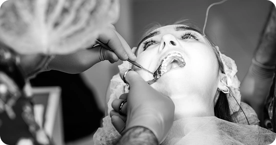 Dentist performing treatment on a female patient in black-and-white photo