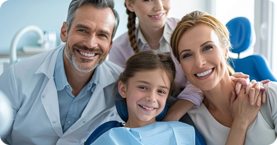 Smiling family with daughter sitting in dental chair during a checkup.