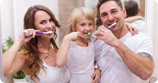 Happy family brushing teeth together promoting good oral hygiene habits.