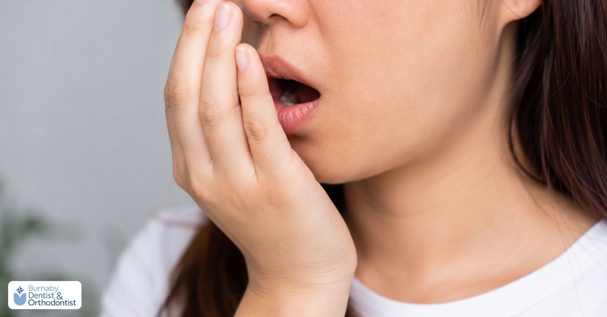 Person covering their mouth due to persistent bad breath, with emphasis on oral hygiene and early gum health concerns.