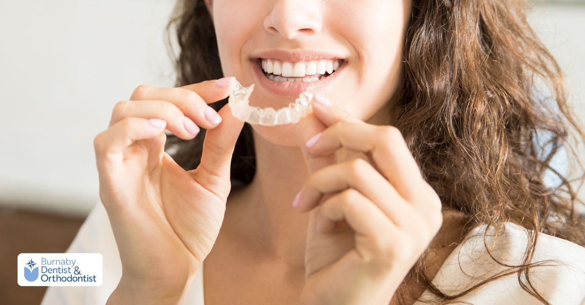 Clear removable retainer held in hands illustrating common signs that a new retainer is needed.