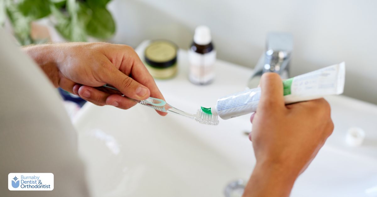 A person applying whitening toothpaste to a toothbrush for routine oral care and surface stain removal