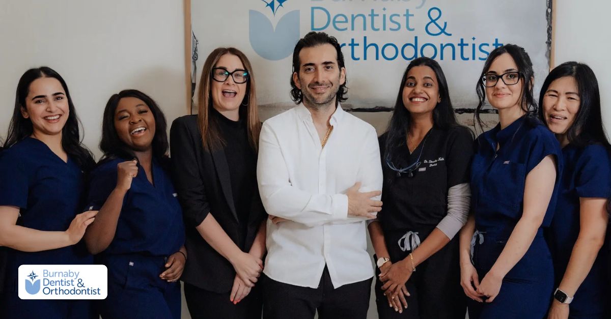 Team photo of smiling dental and orthodontic staff standing together at Burnaby Dentist & Orthodontist in their clinic.