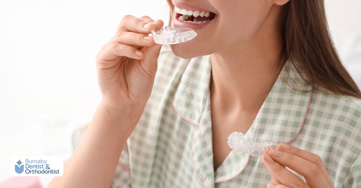 Nightguard vs. Sports Mouthguard in Burnaby: Custom Fit with Digital Scans Person holding two clear dental mouthguards, one for night use and one for sports.